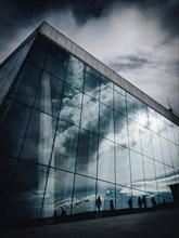 Silhouettes reflected in the façade of the opera house in Oslo