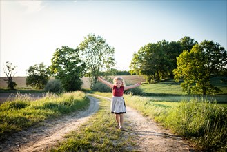Child singing while walking along a country lane