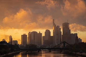 Low-hanging rain clouds surround Frankfurt's banking skyline and glow in the light of the setting evening sun.