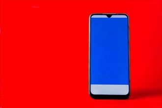 Mobile phone with blue screen isolated on a red background