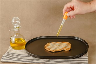 Woman pours olive oil on toast with an dropper because of excessive oil prices