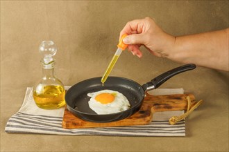 Woman hand frying an egg