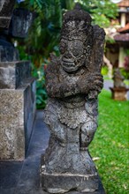 Park with tropical plants and traditional statues of the Hindu faith and for decoration. Tropical island life as a tourist on Bali