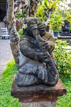 Park with tropical plants and traditional statues of the Hindu faith and for decoration. Tropical island life as a tourist on Bali