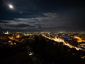 View from the Schlossberg at full moon of the city of Graz illuminated at night