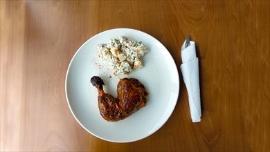 Overhead view of smoked chicken thigh and classic potato salad