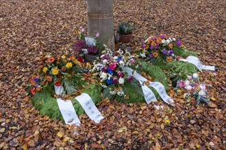 Flower wreaths on a memorial tree with the names of those buried there in Seelwald