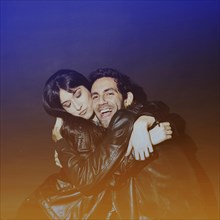 Attractive lady hugging laughing guy leather jackets