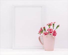 Carnation flowers vase with empty frame table