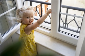 Child looking through window during quarantine
