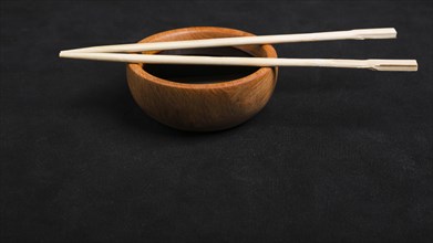 Chopsticks soya sauce wooden bowl black backdrop