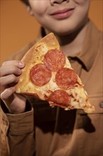 Close up child holding pizza slice