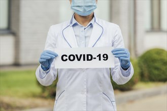 Close up doctor holding covid sign