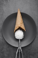 Cone with vanilla ice cream scoop