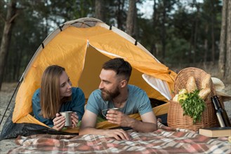 Couple laying down tent looking each other
