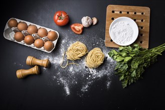 Egg carton vegetables flour spaghetti pasta nest black counter