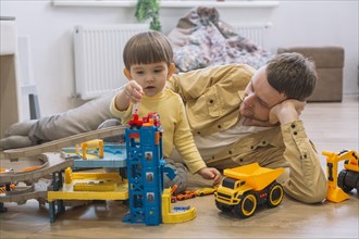 Father son playing with toy cars