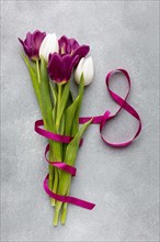 Flat lay bouquet tulips with pink ribbon