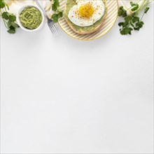 Flat lay pita with avocado spread fried egg plate with copy space