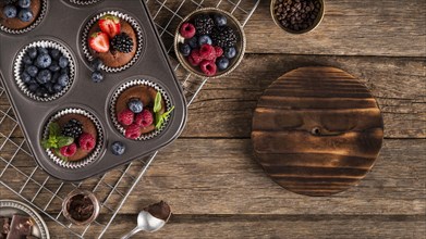Flat lay tasty muffin with forest fruit baking tray