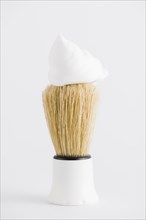 Foam synthetic shaving brush against white backdrop