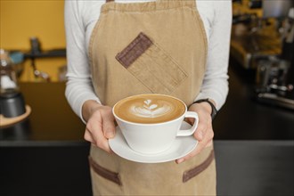 Front view female barista holding decorated cup coffee hands