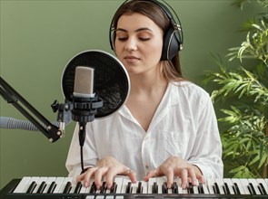 Front view female musician singing playing piano keyboard