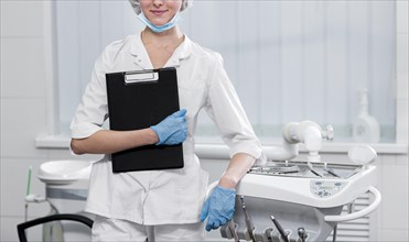 Front view young dentist holding clipboard