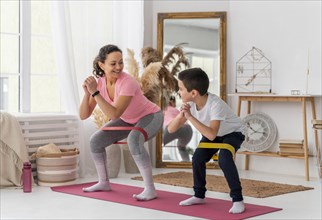 Full shot woman kid training with resistance band