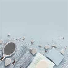 Hair comb napkin soap sponge hand mirror with spa stone salt blue background