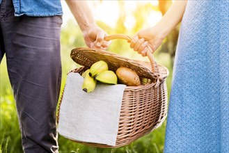 Hands couple holding picnic basket full food