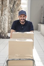 Happy delivery man with cardboard boxes