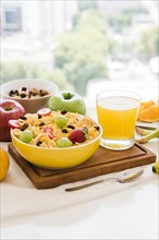 Healthy breakfast with cornflakes dried fruits apple juice glass table