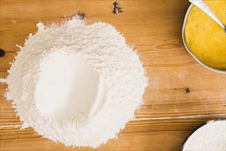 Heap flour near mixed eggs