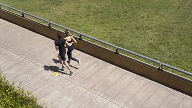 High angle man woman jogging together outside