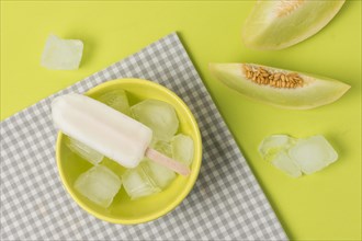 Ice lolly bowl near napkin fresh fruits