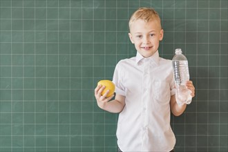 Junior with water apple near chalkboard