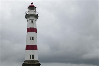 Lighthouse against dark overcast sky