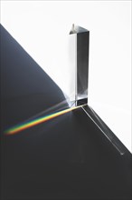 Light passing through triangular prism with dark shadow white surface