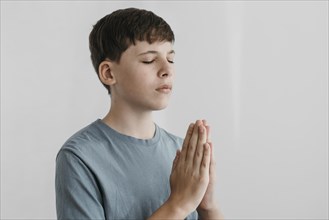 Little boy praying indoors