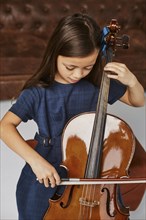 Little cute girl learning how play cello