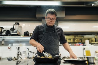 Male chef with apron cooking pasta
