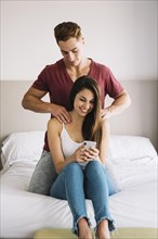 Man massaging shoulder woman bed