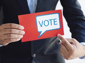 Man pointing ballot with voting message