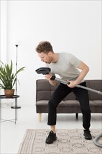Man singing vacuum while cleaning
