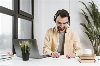 Man with headset having video call laptop