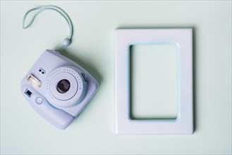 Mini instant camera empty border frame blue background