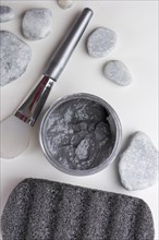 Overhead view spa stones brush clay mask pumice stone white background