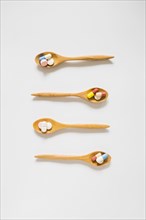 Overhead view wooden spoons with pills