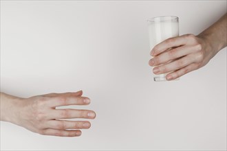 Person handing glass milk another one